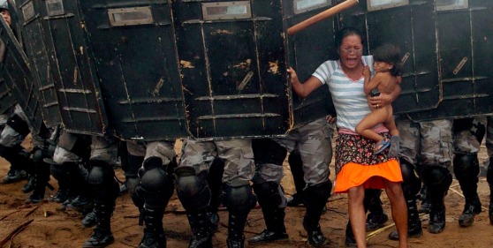 An indigenous woman holds her child while trying to resist the advance of Amazonas state policemen in Manaus who have been sent to evict natives. [2008]